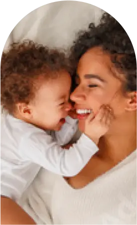 Mom and baby smiling on bed - Protect your family from bed bug bites with Seitz Brothers in Tamaqua PA